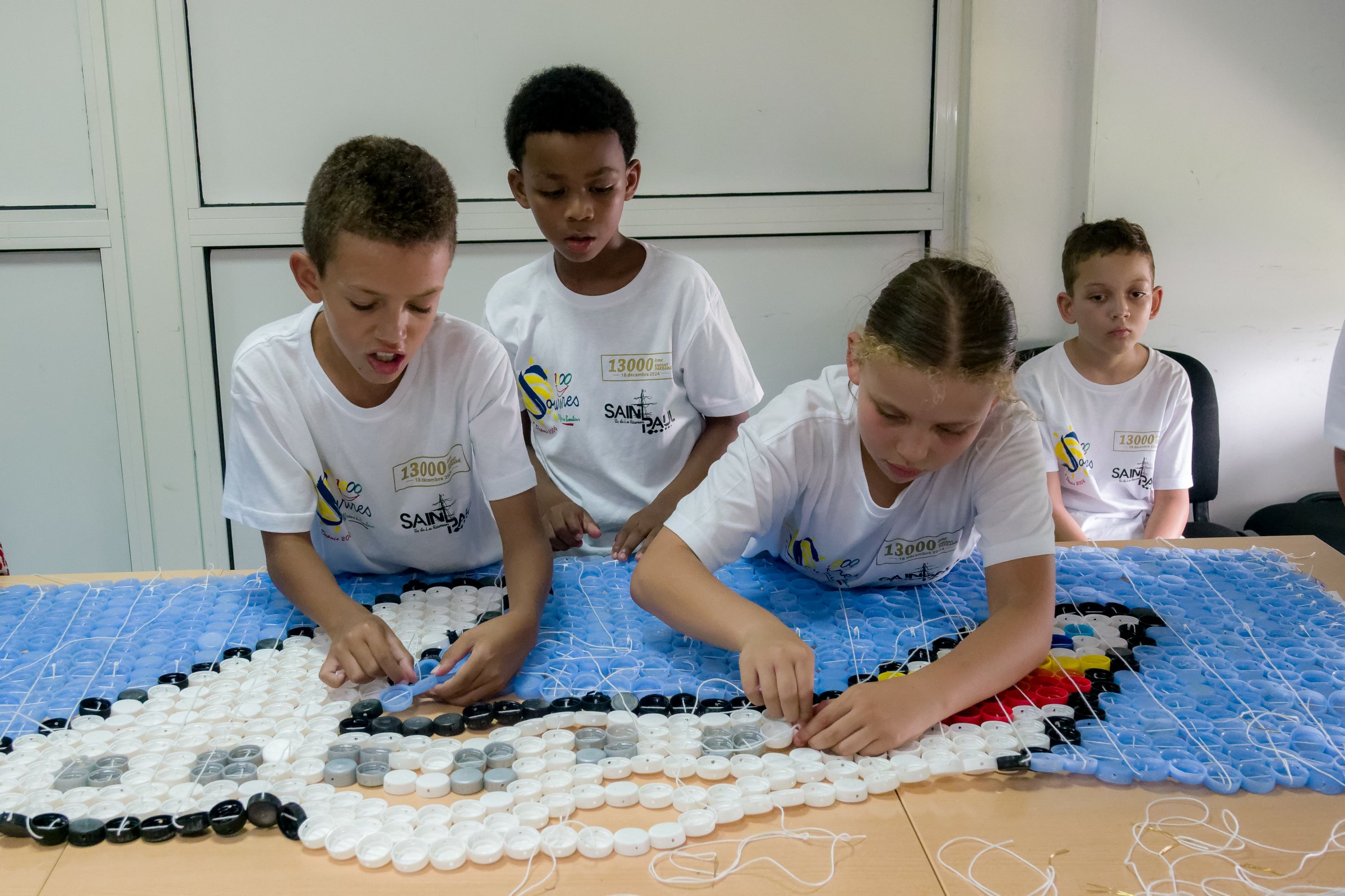 <center>Les marmailles de 1000 Sourires réalisent une fresque de plus de 5000 bouchons pour Air Austral